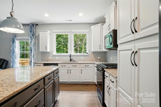 25622 Seagull Dr Unit 645, Lancaster, SC 29720 - kitchen featuring gas range oven, a sink, white cabinets, stainless steel microwave, and dark wood-style floors
