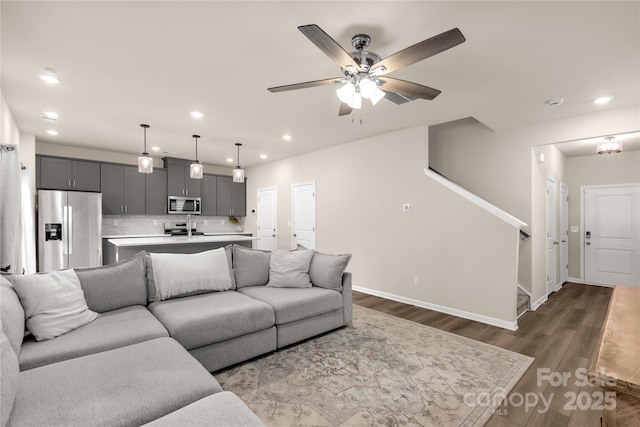 living room featuring ceiling fan, hardwood / wood-style floors, and sink