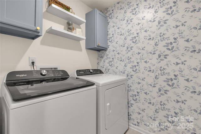 clothes washing area featuring cabinets and independent washer and dryer