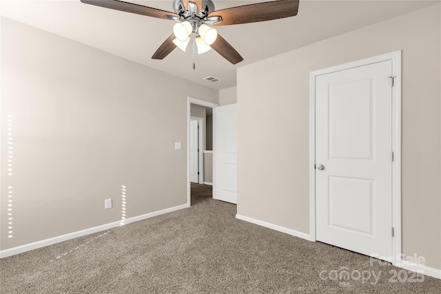 unfurnished bedroom with ceiling fan and dark carpet