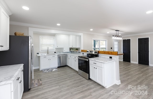 kitchen featuring white cabinetry, appliances with stainless steel finishes, pendant lighting, kitchen peninsula, and light hardwood / wood-style flooring