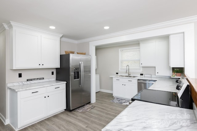 kitchen with crown molding, appliances with stainless steel finishes, sink, light hardwood / wood-style floors, and white cabinets