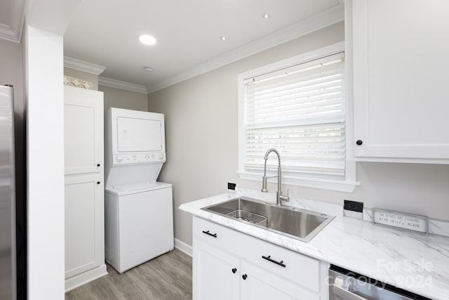 washroom featuring ornamental molding, stacked washer and dryer, light hardwood / wood-style floors, and sink