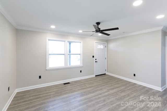 empty room with light wood-type flooring, ceiling fan, and ornamental molding