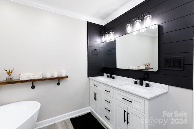 bathroom with a tub to relax in, vanity, hardwood / wood-style flooring, and crown molding