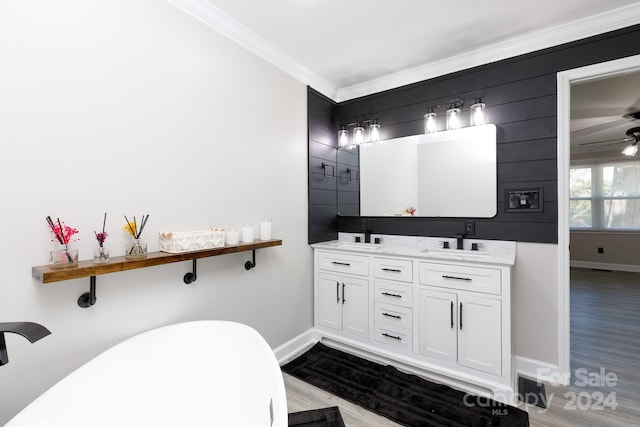 bathroom with a washtub, vanity, hardwood / wood-style floors, and crown molding