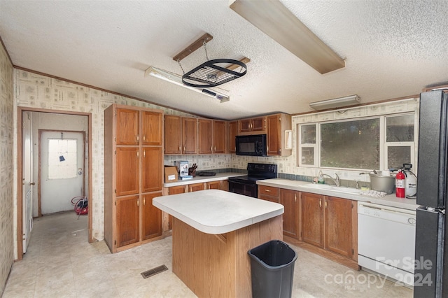 kitchen featuring vaulted ceiling, black appliances, a textured ceiling, sink, and a kitchen island