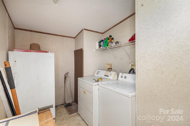 clothes washing area featuring separate washer and dryer, a textured ceiling, and crown molding