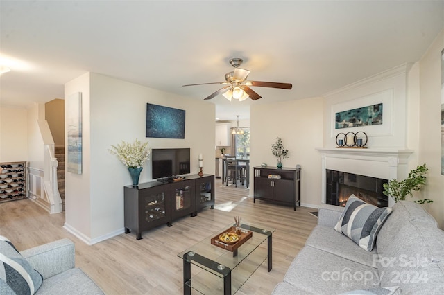 living room featuring light hardwood / wood-style floors and ceiling fan with notable chandelier