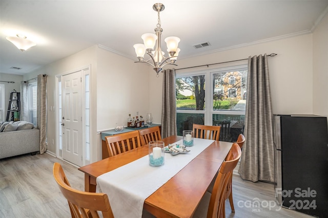 dining room with a chandelier, light hardwood / wood-style floors, and crown molding