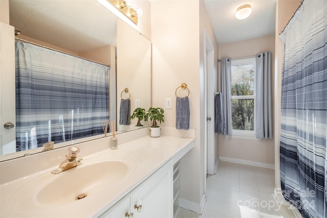 bathroom with vanity, a textured ceiling, and tile patterned floors