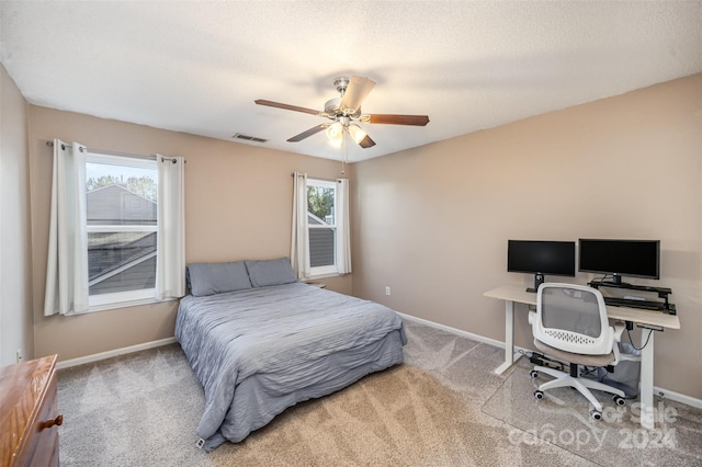 bedroom with multiple windows, a textured ceiling, carpet flooring, and ceiling fan