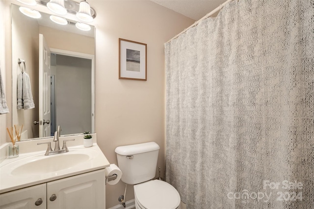 bathroom featuring toilet, vanity, and a textured ceiling