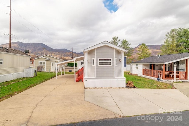 view of front facade with a front yard, covered porch, and a mountain view