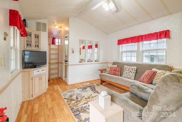 living room featuring light hardwood / wood-style floors, ceiling fan, and vaulted ceiling