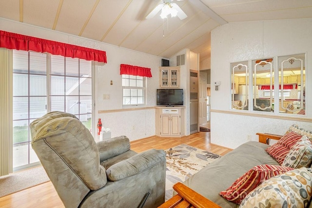 living room with ceiling fan, light wood-type flooring, and lofted ceiling with beams