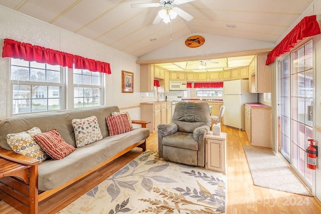 living room with light hardwood / wood-style floors, ceiling fan, sink, and vaulted ceiling