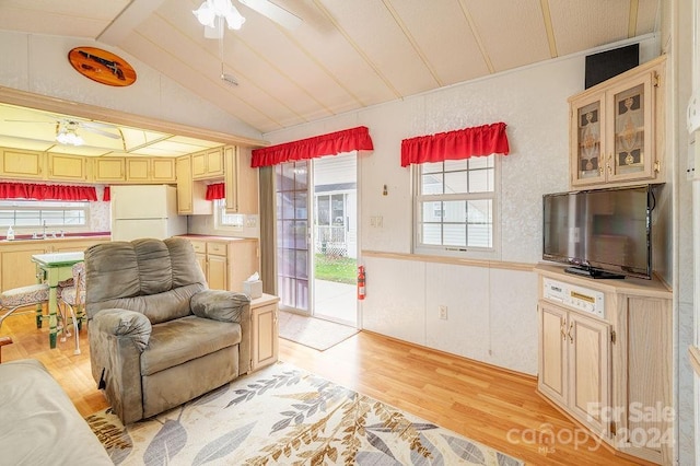 living room with ceiling fan, sink, light wood-type flooring, and vaulted ceiling