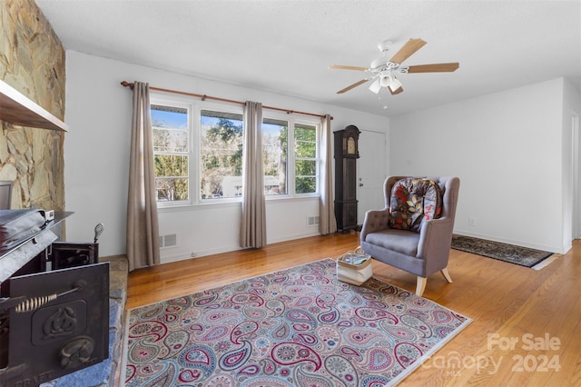 living area featuring light hardwood / wood-style floors and ceiling fan