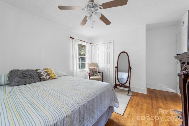 bedroom featuring a closet, ceiling fan, hardwood / wood-style flooring, and a textured ceiling