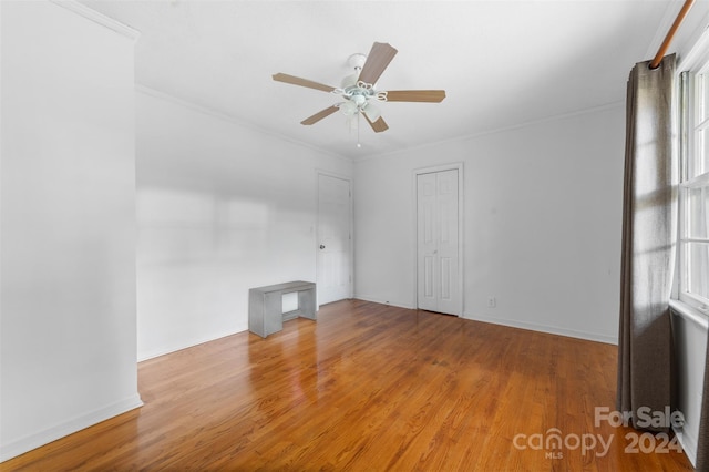 spare room with crown molding, wood-type flooring, and ceiling fan