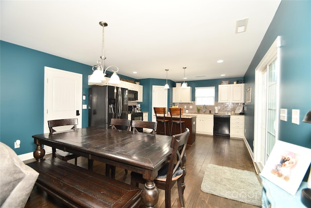 dining space featuring a notable chandelier and dark hardwood / wood-style floors