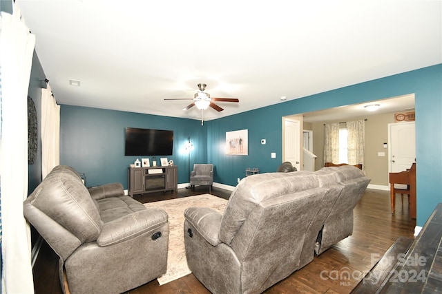 living room featuring ceiling fan and dark hardwood / wood-style flooring