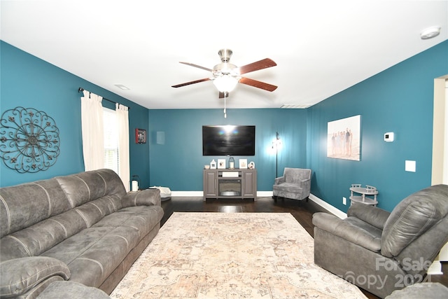 living room with dark wood-type flooring and ceiling fan