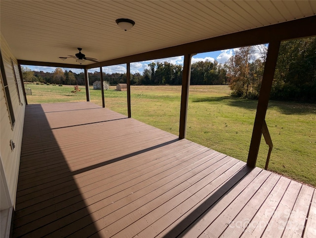 wooden deck featuring ceiling fan and a yard