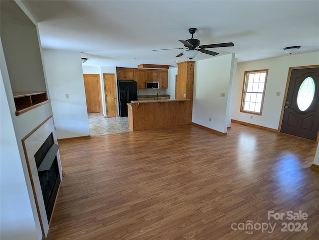 unfurnished living room with dark hardwood / wood-style flooring, ceiling fan, and sink