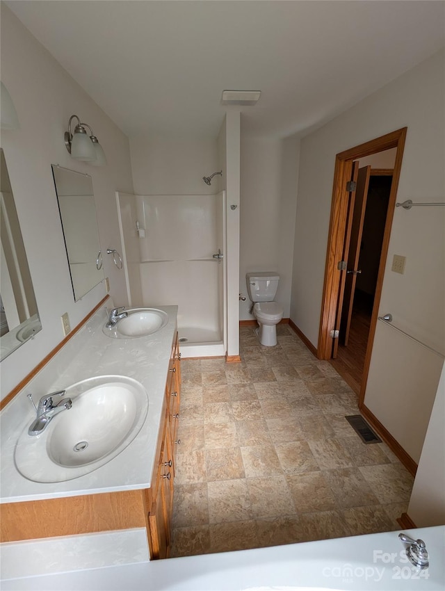 bathroom with walk in shower, vanity, and toilet