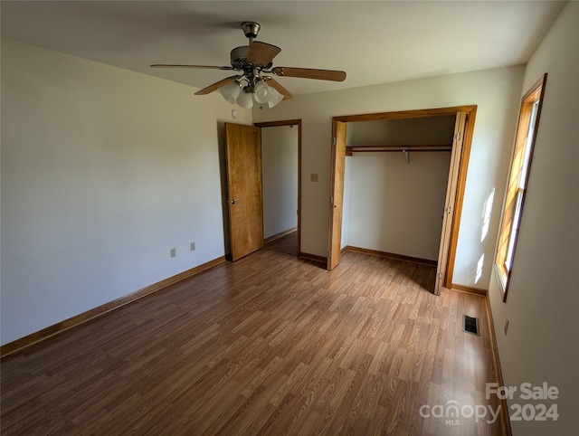 unfurnished bedroom with a closet, light wood-type flooring, multiple windows, and ceiling fan