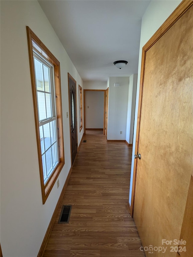 corridor with dark hardwood / wood-style flooring