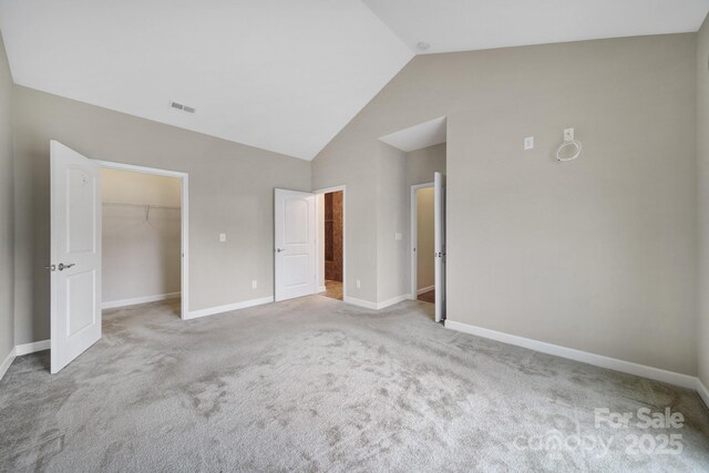 4919 Polo Gate Blvd, Charlotte, NC 28216 - unfurnished bedroom featuring vaulted ceiling, a walk in closet, baseboards, carpet floors, and a closet
