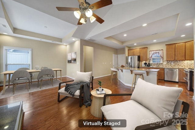 4919 Polo Gate Blvd, Charlotte, NC 28216 - living room with a raised ceiling, plenty of natural light, baseboards, dark wood finished floors, and recessed lighting