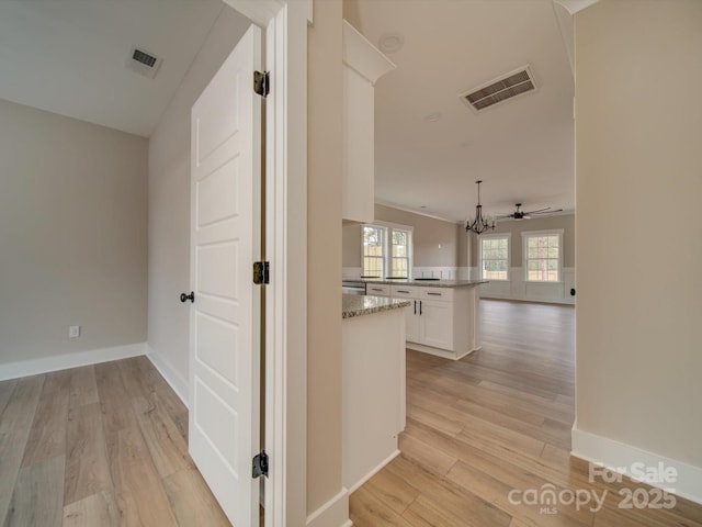 corridor featuring light hardwood / wood-style flooring and a chandelier