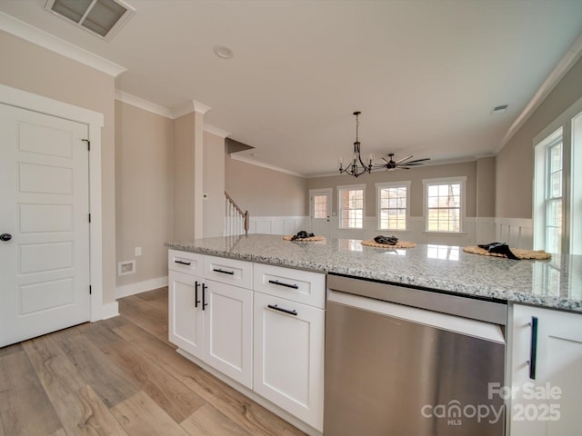 kitchen featuring light stone counters, white cabinets, stainless steel dishwasher, and ornamental molding