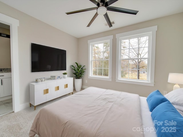 carpeted bedroom with ceiling fan and ensuite bath