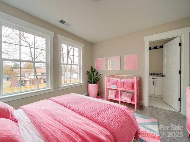 bedroom featuring carpet and connected bathroom