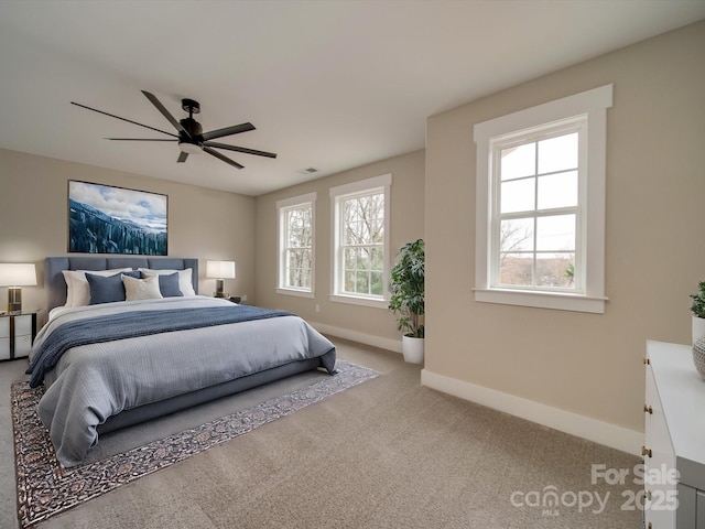 carpeted bedroom with ceiling fan and multiple windows