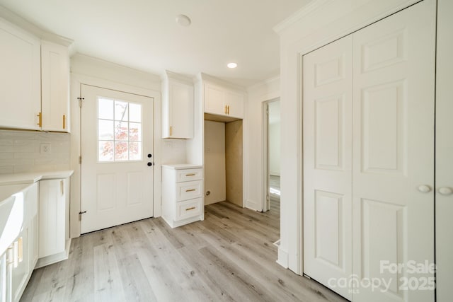 interior space with light wood-type flooring and ornamental molding