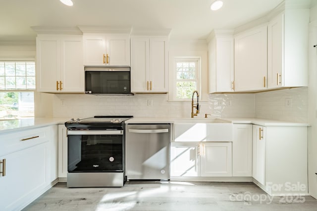 kitchen with decorative backsplash, appliances with stainless steel finishes, white cabinetry, and plenty of natural light