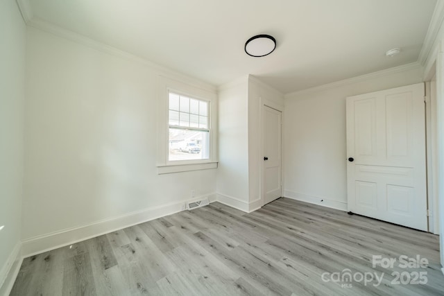 unfurnished bedroom featuring light wood-type flooring, ornamental molding, and a closet