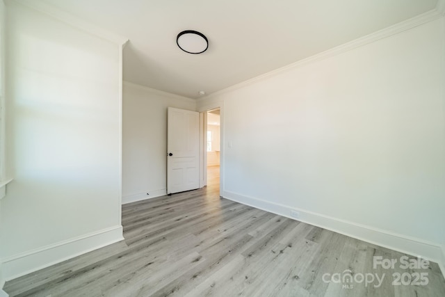 empty room featuring light hardwood / wood-style floors and ornamental molding