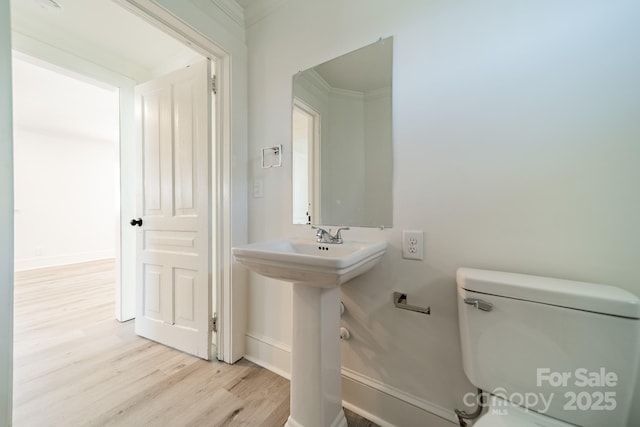 bathroom featuring crown molding, hardwood / wood-style floors, sink, and toilet