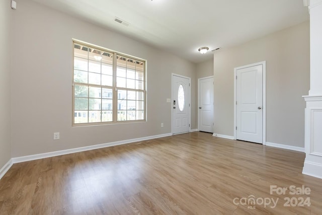 entrance foyer featuring decorative columns and light hardwood / wood-style flooring