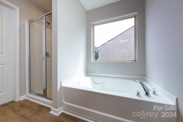 bathroom with hardwood / wood-style floors and independent shower and bath