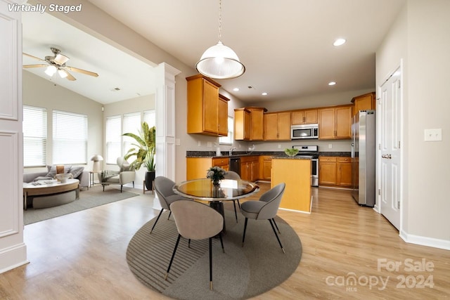 dining space featuring light hardwood / wood-style floors, ceiling fan, and lofted ceiling