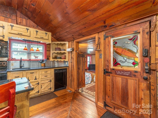 kitchen with a sink, dark countertops, lofted ceiling, black appliances, and wood-type flooring
