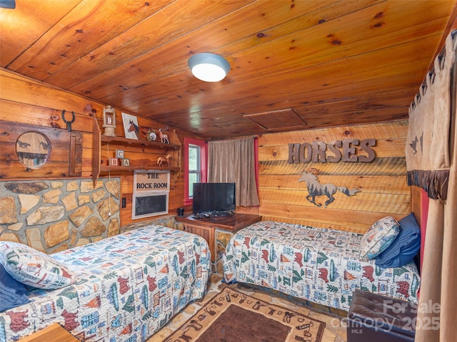 bedroom featuring attic access, wooden ceiling, and wood walls